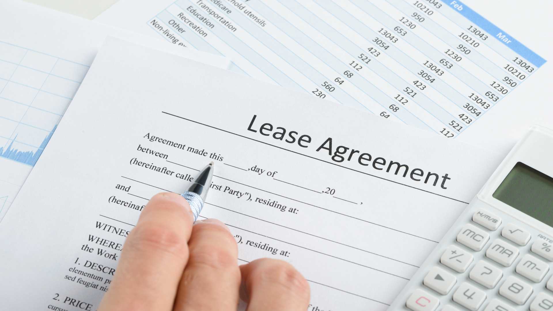 Filling out lease agreement with calculator and expenses